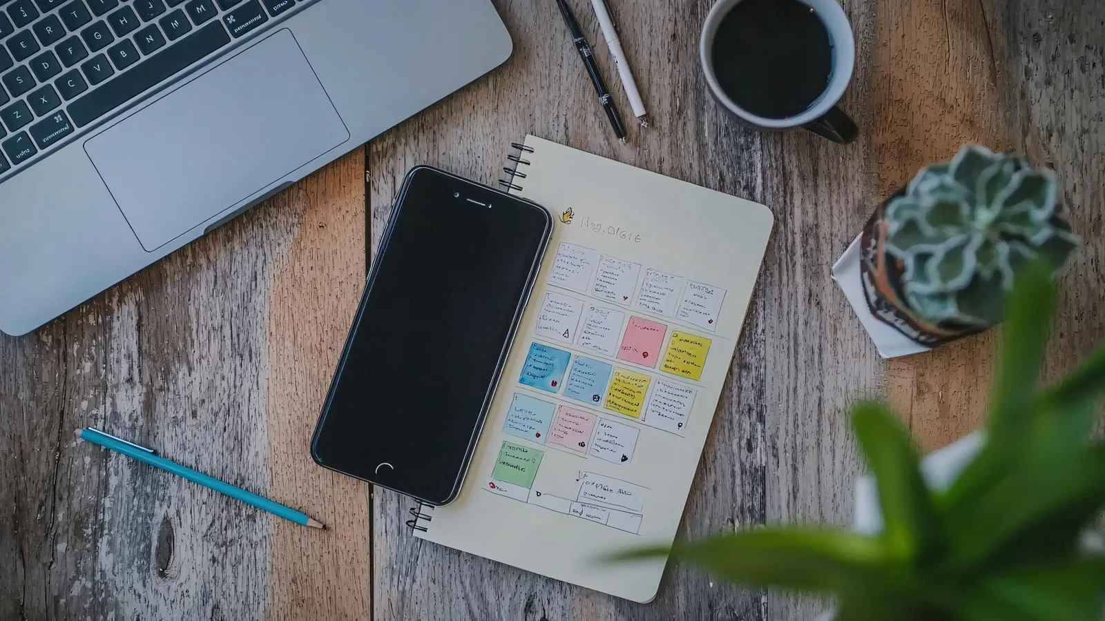 Calendario editoriale per la pianificazione dei contenuti su una scrivania con planner, note colorate e smartphone